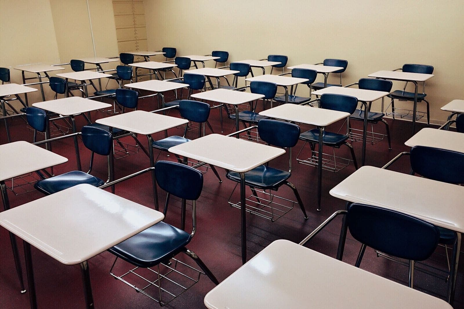 Empty classroom with ordered desks and clean tile flooring