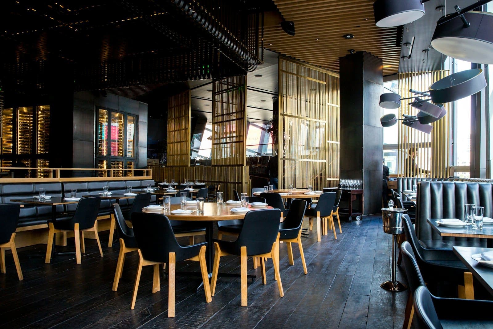 Upscale restaurant dining room with set tables and polished wood floors
